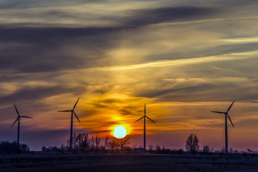 Windmills in northern Germany in the evening with cloudy sky and sunset