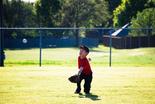 Little league baseball player diving for ball.