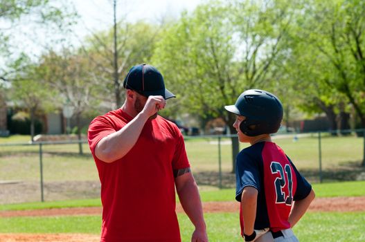 Baseball coach giving signals to teen player