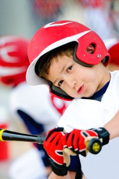 Little league baseball player swinging the bat up close.