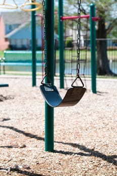 A swing at a playground at a park.