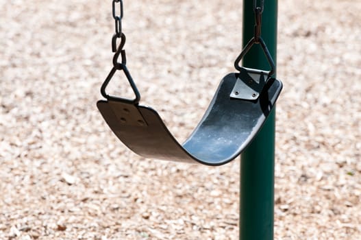 Up-close shot of swing at a playground.