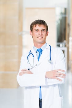 Portrait of a doctor standing in the office and crossed his arms