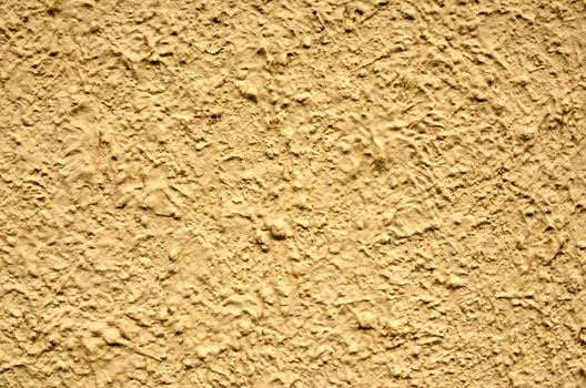 A yellow stucco wall useful for backgrounds or textures