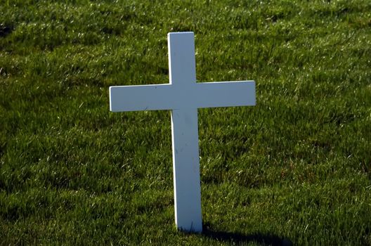 A lone marble cross at a cemetery