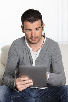 man using tablet pc sitiing on sofa at home