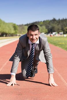 young businessman on a running track in summer