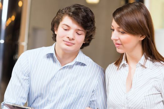 Attractive young man and woman sitting on the floor talking