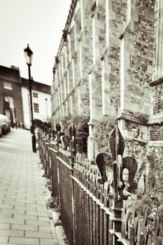 Old church and railings in an English town in sepia with image distortion