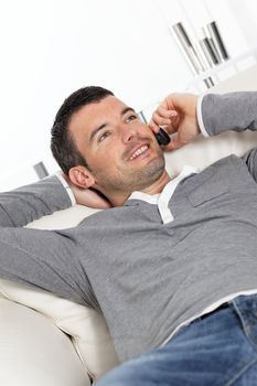 man phoning on sofa