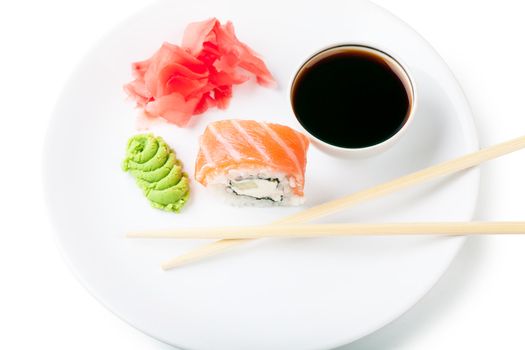 Sushi, soy and ginger with chopsticks on a white plate