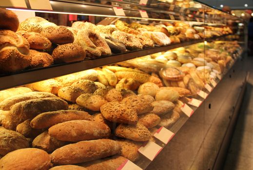 different appetizing bread on showcase in supermarket