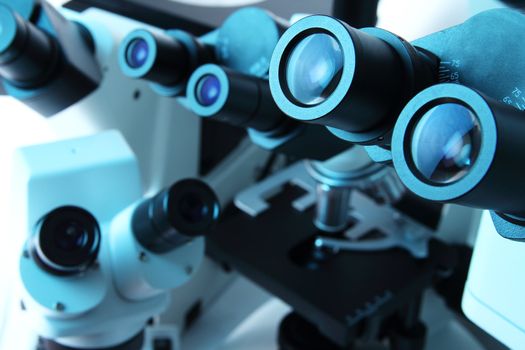 Many laboratory microscopes in blue light