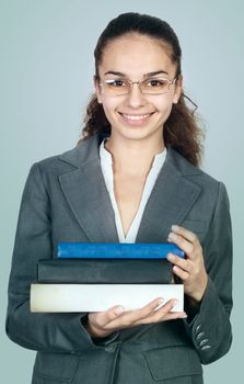 Female student with stack of books on blue background