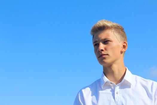 Portrait of a young man on blue sky background