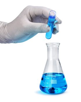 Gloved hand pours blue liquid laboratory test sample