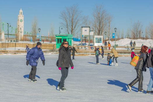  A woman is enjoying the cold winter breeze while ice skating really fast in the Skating Rink in Old Port of Montreal, Quebec ,Canada