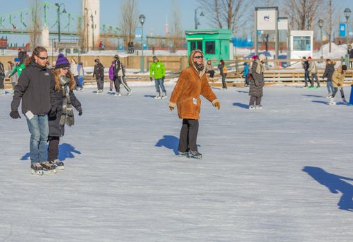 A woman is enjoying ice skating really fast in the Skating Rink in Old Port of Montreal, Quebec ,Canada
