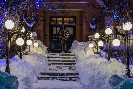 A beautiful entrance with lamps of an amazing house in a cold winter night in Quebec, Canadayear; wreath; winter; wall; vertical;