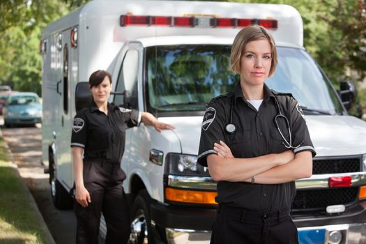 Confident emergency medical team portrait standing with ambulance in background