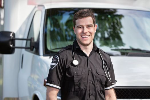 Portrait of happy smiling man paramedic in front of ambulance