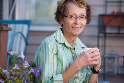 Portrait of smiling senior woman enjoying a warm drink