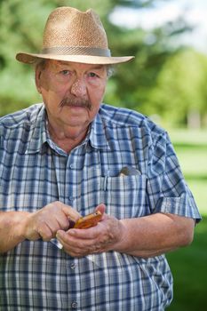 Portrait of senior man text messaging in park