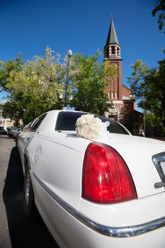 Wedding limo outside of church waiting for bridal couple