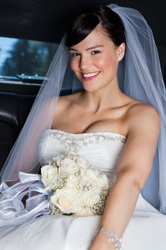 Portrait of happy beautiful bride in limousine