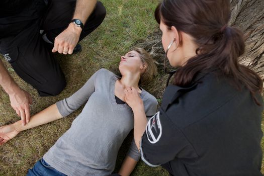 First responder medical team attending to sick woman