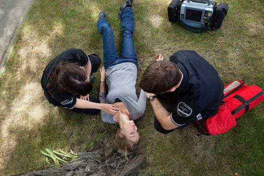 Emergency medical team responding to a woman in a park