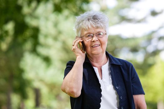 Portrait of smiling senior woman having conversation on mobile phone