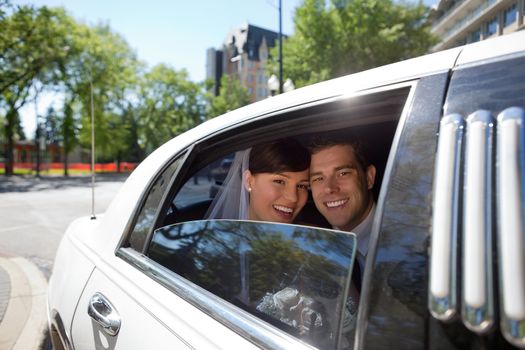 Portrait of newlywed couple in limousine