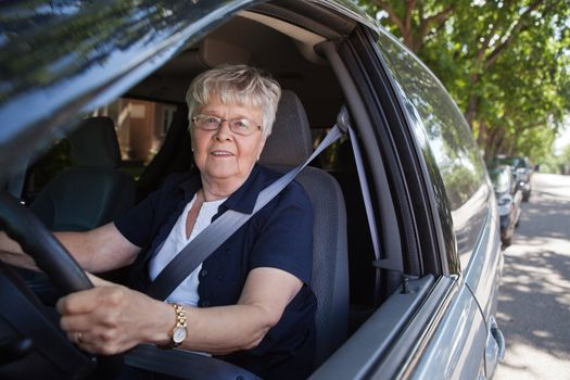 Portrait of smiling old woman driving car