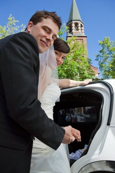 Portrait of newlywed couple getting in the car