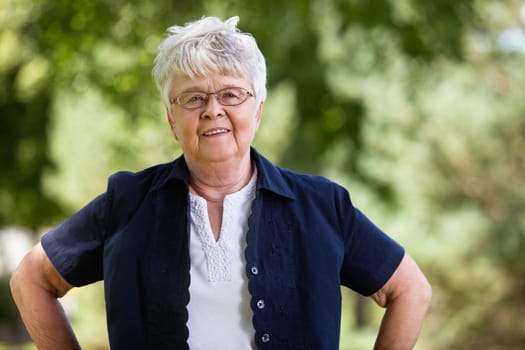 Portrait of confident elderly woman in park