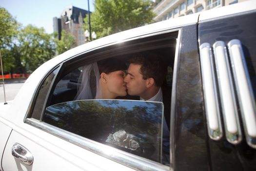 Newlywed Couple Kissing Each Other In Limousine.