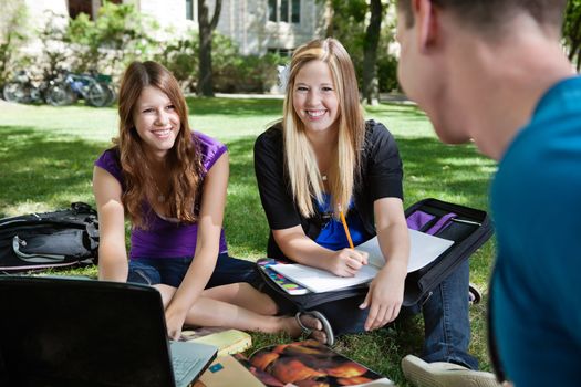 Three classmates studying together outdoors