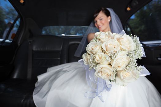 Attractive bride showing off her flower bouquet