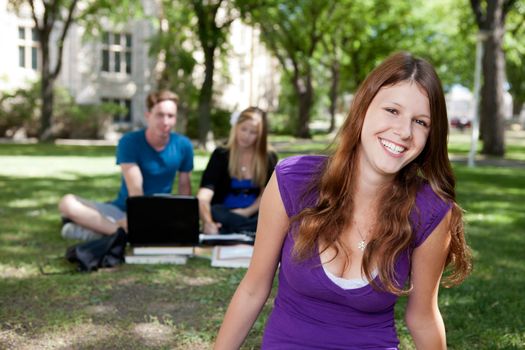 Happy brunette student smiling at the camera