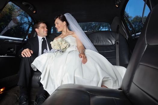 Newlywed bride and bridegroom in car