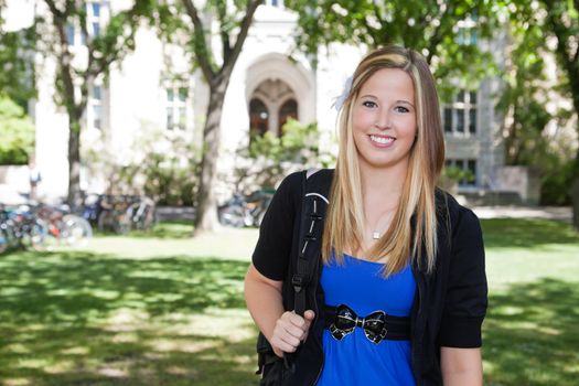 Portrait of a cute teenage girl holding backpack