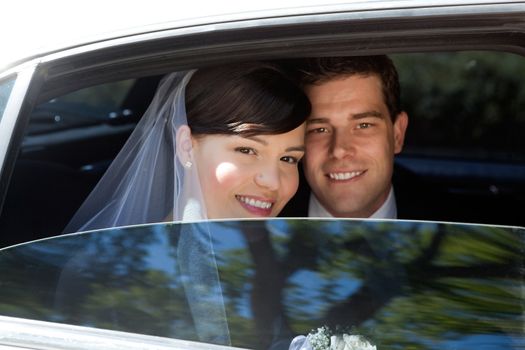 Portrait Of Newlywed Couple Smiling Sitting In Limousine