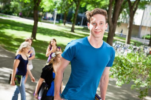 Portrait of boy going college with friends in background