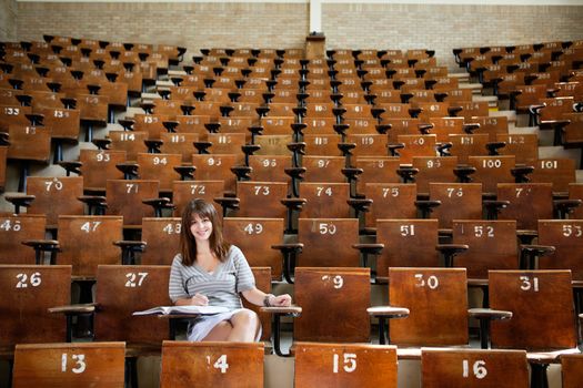 Smiling young student in empty lecture hall