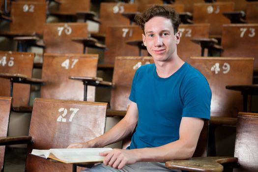 Portrait of young university student sitting in lecture hall