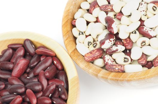 Two Wooden Bowls with Red, White and Variegated Bean on white background. Top View