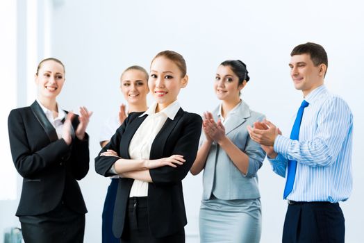 successful business woman in the office, around applauding colleagues