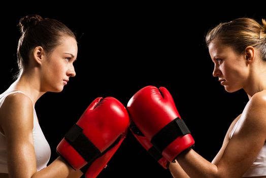 two female boxers face each other, pushing the boxing gloves, start a fight