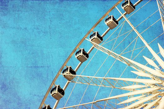 Close up of ferris wheel with blue sky, photo in old image style